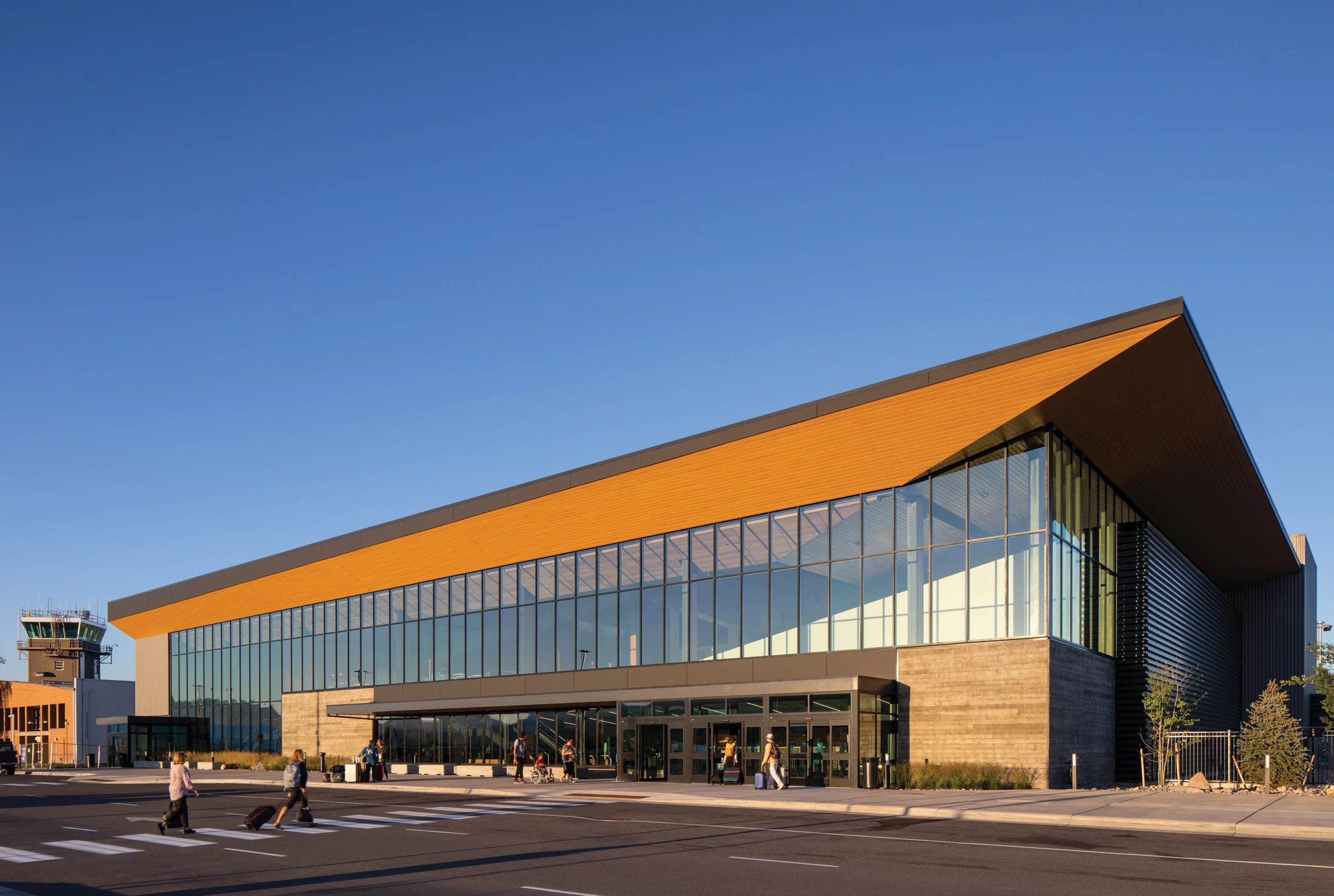 Exterior view of Missoula Montana Airport showcasing a 'Montana Modern' design with expansive glass walls and a flat roofline rising to the west.