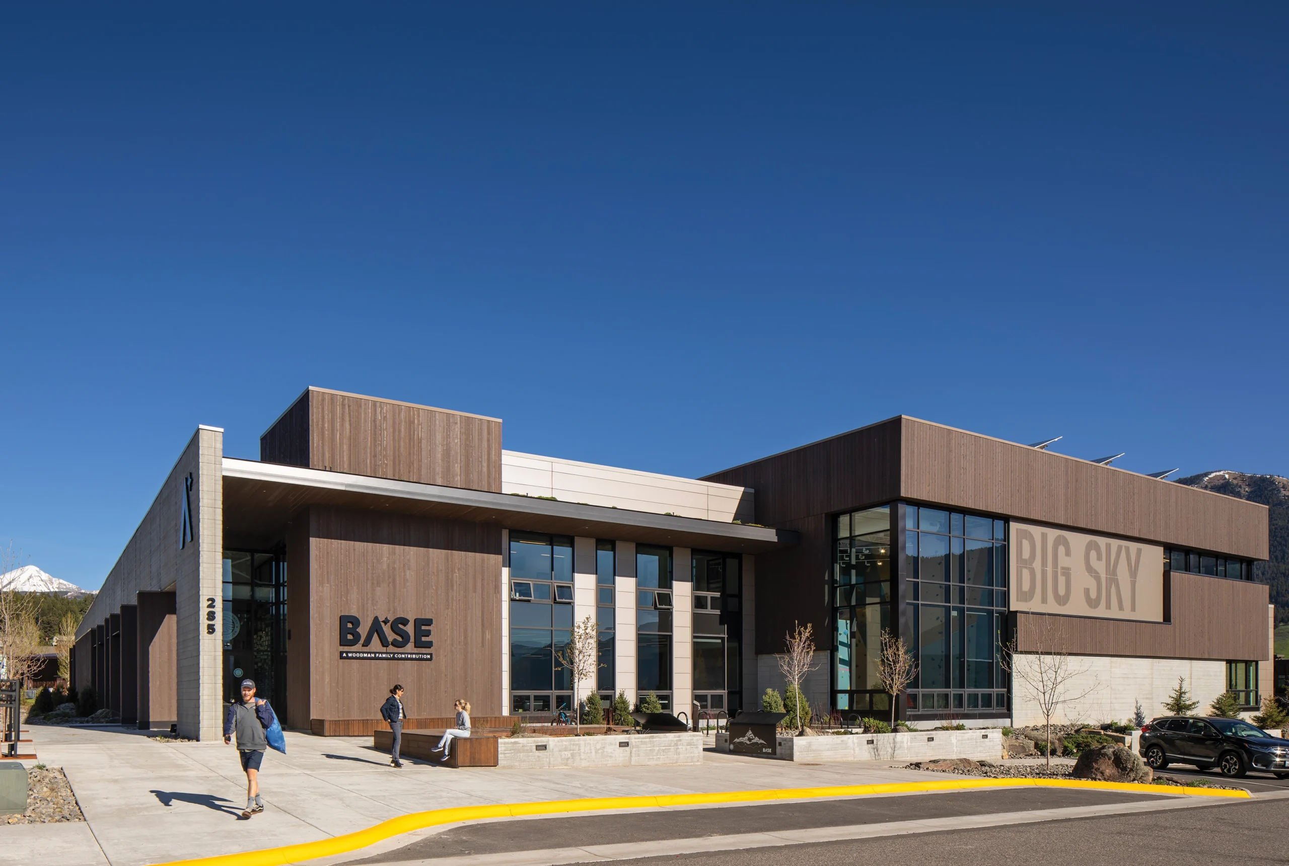 BASE Community Center exterior, showcasing a blend of wood, glass, and concrete materials that harmonize with the surrounding landscape.