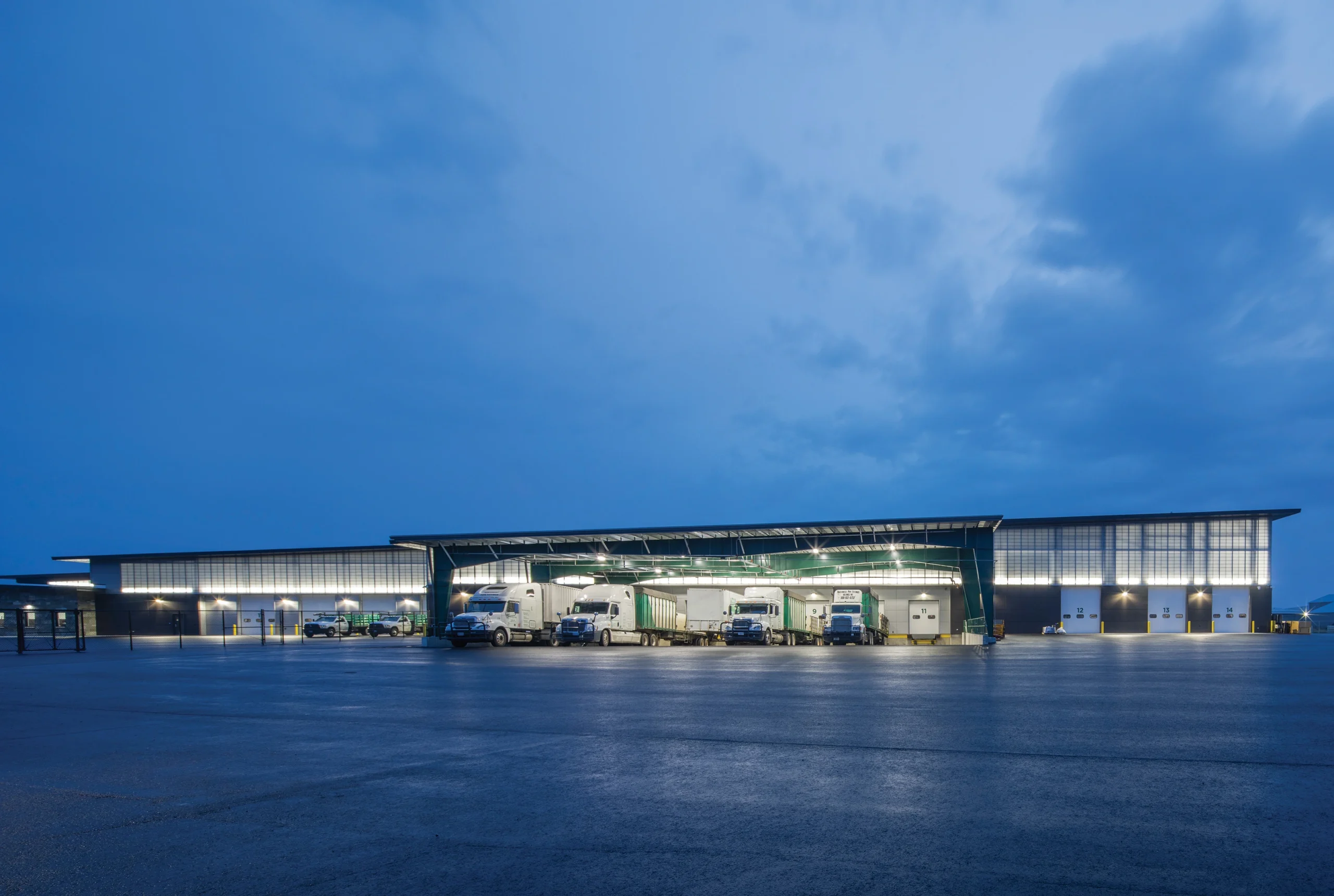 Northwest Pipe Fittings distribution center at dusk, featuring a covered loading dock, illuminated façade, and expansive warehouse space designed for efficiency and functionality.