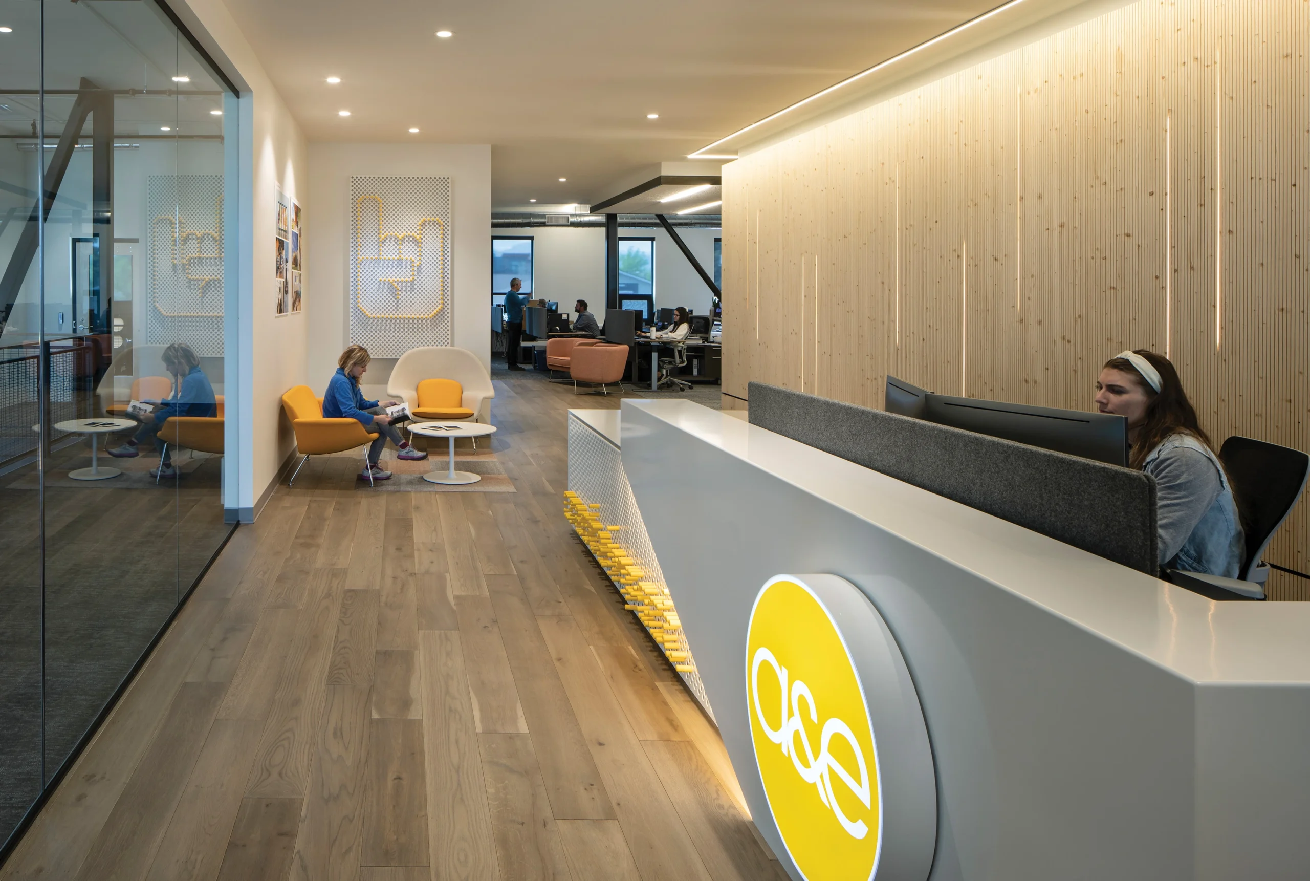 Lobby featuring a contemporary reception desk and interactive signage, showcasing environmental graphic design that blends branding with modern design.